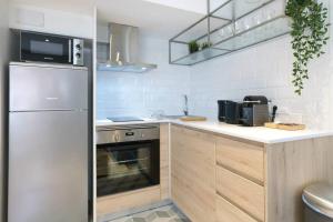 a kitchen with a refrigerator and a counter top at EIFFEL BRIDGE BOUTIQUE APARTMENT in Girona