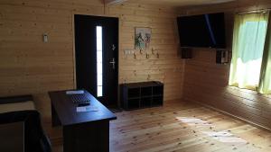 Pokój z biurkiem i drzwiami z telewizorem w obiekcie Ośrodek dla niepalących Woodland Resort w mieście Zamość