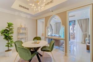a dining room with a table and green chairs at Durrani Homes - Souk Al Bahar Luxury Living with Burj & Fountain Views in Dubai