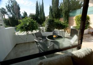 a patio with a table and chairs on a balcony at Pissouri Bay Villa in Pissouri