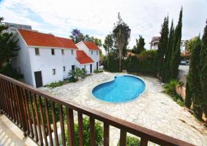 a swimming pool sitting on a patio next to a house at Pissouri Bay Villa in Pissouri