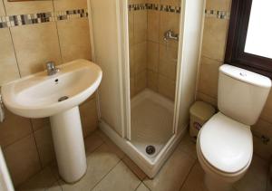 a bathroom with a sink and a shower and a toilet at Pissouri Bay Villa in Pissouri +8 photos