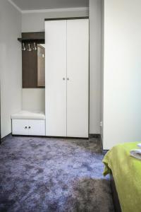 a white bathroom with a sink and a cabinet at Rajska Oaza in Przybradz