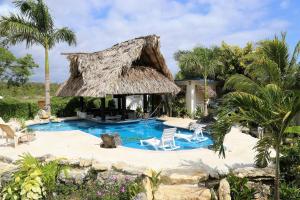 een resort met een zwembad en een rieten hut bij The GECKO BUNGALOW**Beautiful POOL**Free Airport Shuttle in Belize City