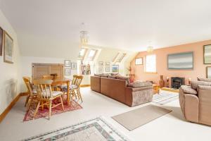 a living room with a table and a couch at Muir Park Cottage , 5 Mins to St Andrews , Parking in St. Andrews