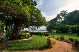 a park with benches and a view of the water at Miridiya Lake Resort in Anuradhapura