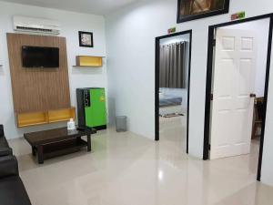 a living room with a door and a tv at Tho Mai Resort in Wang Chan