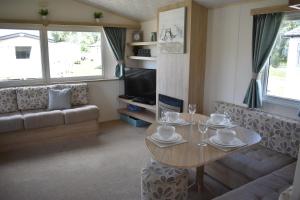 a living room with a table and a couch at The Salsa Attractive accomodation at Tattershall Lakes in Tattershall