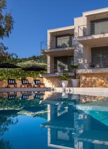 a house with a swimming pool with chairs and a building at Tara's Lodge Hotel in Korčula