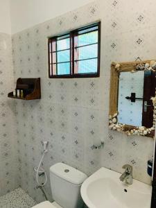 La salle de bains est pourvue de toilettes, d'un lavabo et d'un miroir. dans l'établissement Zava Nungwi, à Nungwi