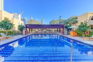 a large swimming pool with a gazebo in a building at Durrani Homes - Souk Al Bahar Luxury Living with Burj & Fountain Views in Dubai