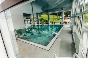 an indoor swimming pool in a building with windows at Kompleks Beskid in Spytkowice