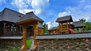 ein Haus mit Spielplatz und Spielstruktur in der Unterkunft Pensiunea Inima Maramureșului in Breb