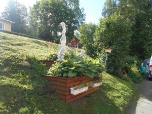a statue in a garden with plants in a yard at Perniön Majoitus 6 in Perniö