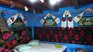 um quarto com uma cama num quarto decorado com flores em Pensiunea Inima Maramureșului em Breb