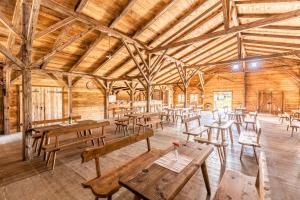 um quarto com mesas de madeira e bancos num celeiro em Almdorado em Übersee