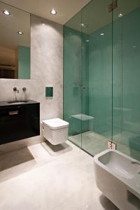 y baño con ducha de cristal, aseo y lavamanos. en Serviced Apartments Boavista Palace en Oporto