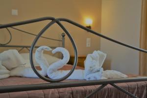 a metal bed with towels in the shape of hearts at MARIANNA in Sidari