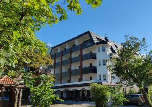 biały budynek z czarnym dachem w obiekcie Park Hotel Villa Etschland w mieście Plaus
