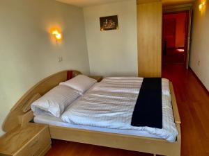 een groot bed in een slaapkamer met een houten vloer bij Hôtel Lion d'Or Romont in Romont