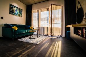 a living room with a green couch and a table at Apartament WIDOK in Olsztyn