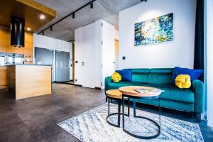 a living room with a green couch and a table at Apartament WIDOK in Olsztyn