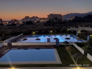 uitzicht op een groot zwembad in de nacht bij Apartamento Jardines del Campanario in Torrox