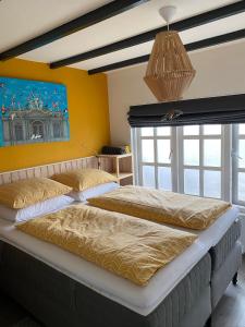 a bedroom with two beds and a large window at Appartement Bos en Duin in Vogelenzang