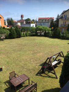 a picnic table and a bench in a yard at Pensjonat ''TRYTON'' in Karwia +8 photos