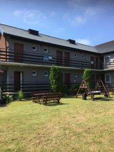 a building with benches in front of it at Pensjonat ''TRYTON'' in Karwia
