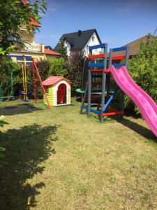 a playground with a slide and a dog house at Pensjonat ''TRYTON'' in Karwia