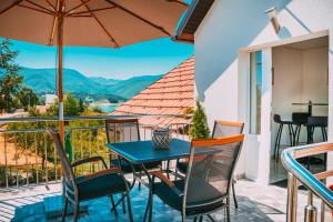 a table and chairs on a balcony with a view at Apartmani Markešić Ramsko jezero in Prozor