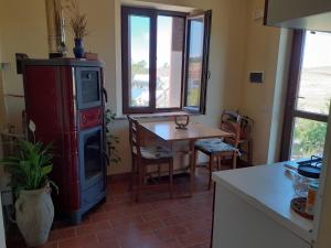 a kitchen with a table and a stove and a kitchen with a table at Agriturismo Enjoy Sunset in Cinigiano