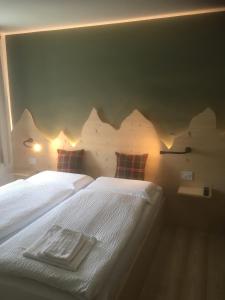 two beds in a bedroom with a mountain mural on the wall at B and B nonna Rosa vista Lagorai in Capriana