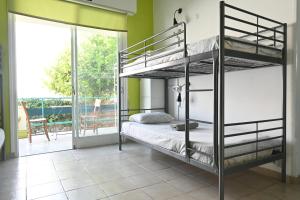 a bedroom with two bunk beds and a balcony at Lemongrass Hostel in Limassol
