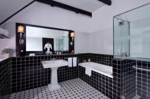 a bathroom with a sink and a tub and a mirror at The Lakehouse Cameron Highlands in Ringlet
