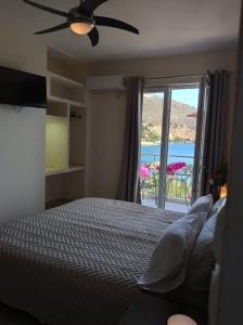 een slaapkamer met een bed en een raam met uitzicht bij Ballas Apartments in Ayia Evfimia