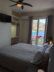 sypialnia z łóżkiem i oknem z widokiem w obiekcie Ballas Apartments w mieście Agia Efimia