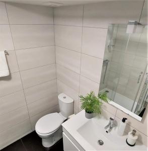 a white bathroom with a toilet and a sink at Anjo33 Flats in Braga