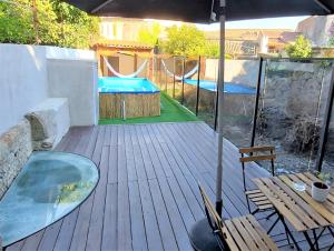 a deck with a pool and a table and an umbrella at Anjo33 Flats in Braga
