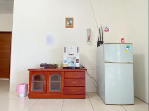 a kitchen with a wooden cabinet next to a refrigerator at Full power in Pa-wang-wei