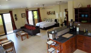 a kitchen and living room with a couch and a table at Casa Cataleya Bohol Self-service Apartments in Panglao