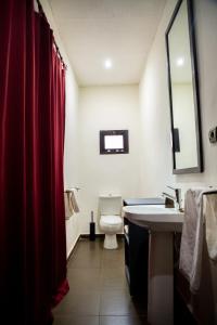 a bathroom with a toilet and a sink and a mirror at Villa Kaya Lodge in Ouagadougou