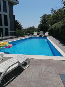 una piscina con 2 tumbonas y una piscina en Boutique Home Apartments en Varna