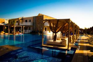 una piscina con sedie e un gazebo in un hotel di Sunshine Hotel Tigaki a Tigaki