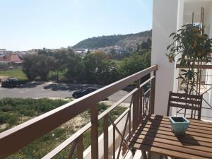 a balcony with a bench and a view of a parking lot at Two bedroom Duplex :Mountain and Sea view in Larnaca