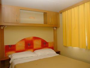 En eller flere senge i et værelse på Camping Costa Ponente