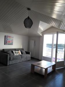 ein Wohnzimmer mit einem Sofa und einem Couchtisch in der Unterkunft APPARTEMENT FACE au PORT et à L'OCEAN SAINT GILLES CROIX DE VIE WIFI BALCON PARKING PRIVE COUVERT in Saint-Gilles-Croix-de-Vie