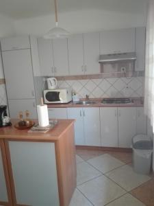 cocina con armarios blancos y microondas en Apartment Kata, en Fažana
