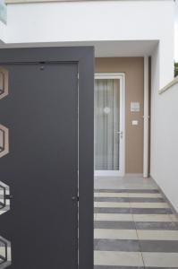 czarne drzwi w budynku z korytarzem w obiekcie Riva 33 Apartments w mieście Porto Cesareo +2 zdjęcia